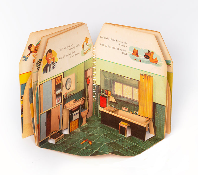 A charming pop-up book, extremely well-preserved, which fold out 360 degrees to create a functioning open walled doll house, containing 4 rooms: a living room, kitchen, bathroom and bedroom.