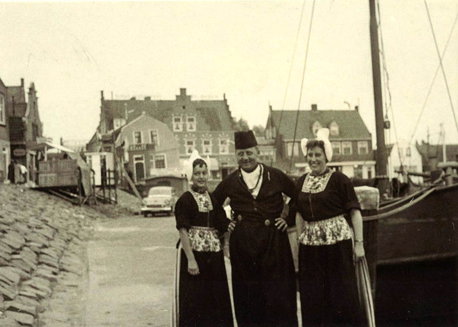 A gelatin silver print by Emil Hoppe, showing a trio wearing traditional regional costume at the Dutch fishing port of Volendam, Holland.