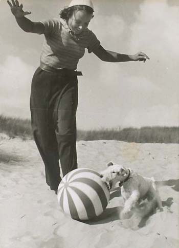 Woman, Dog And Ball On The Beach.