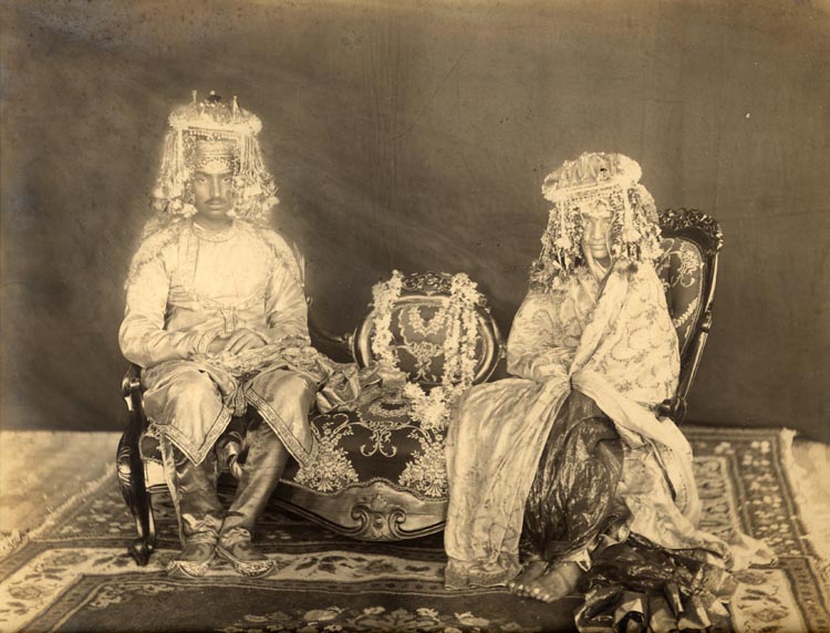 A young Hindu couple sit for their formal wedding portrait circa 1890. A silver print with good tonal range, pasted on original card.