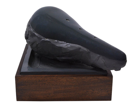 Claes Oldenburg, Sculpture in the Form of a Bicycle Saddle, 1976, cast ceramic, mahogany, sand, signed, from the edition of 36