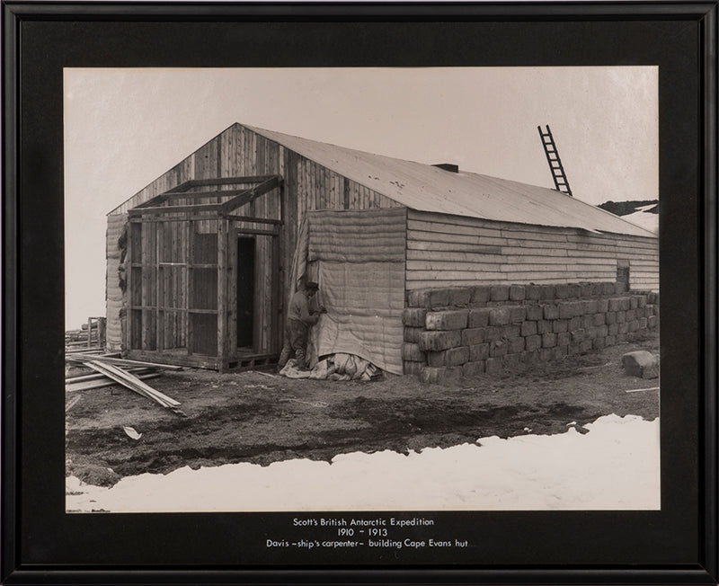 Classic Herbert Ponting photograph from Captain Scott's Terra Nova expedition (1910-1913), showing Davis building the Hut at Cape Evans.