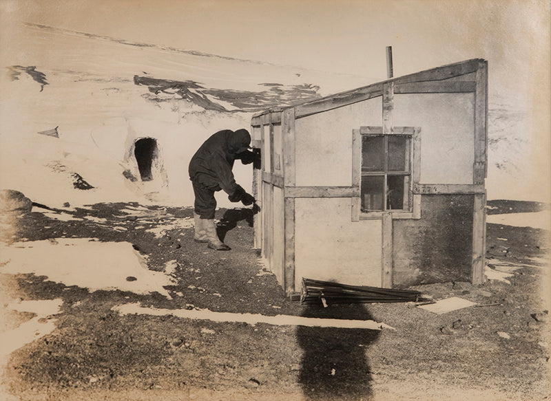 Classic Herbert Ponting photograph from Captain Scott's Terra Nova expedition (1910-1913), showing meteorologist George Simpson and the magnetic hut.