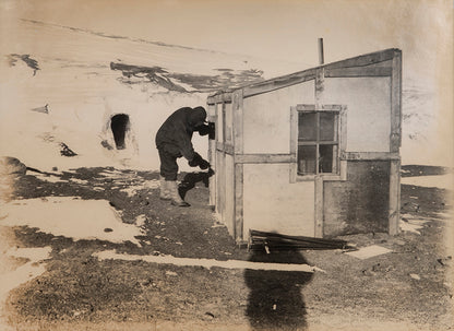 Classic Herbert Ponting photograph from Captain Scott's Terra Nova expedition (1910-1913), showing meteorologist George Simpson and the magnetic hut.