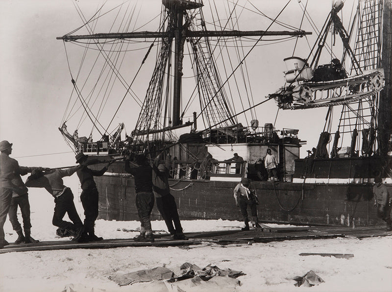 Classic Herbert Ponting photograph from Captain Scott's Terra Nova expedition (1910-1913), showing the unloading of the first motor sledge.