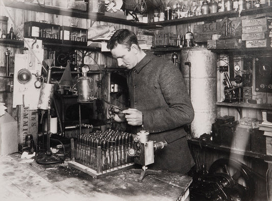 Classic Herbert Ponting photograph from Captain Scott's Terra Nova expedition (1910-1913), showing George Simpson in his laboratory in the Hut.