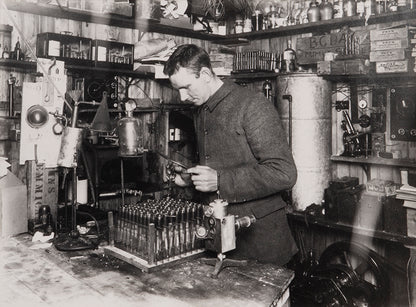 Classic Herbert Ponting photograph from Captain Scott's Terra Nova expedition (1910-1913), showing George Simpson in his laboratory in the Hut.