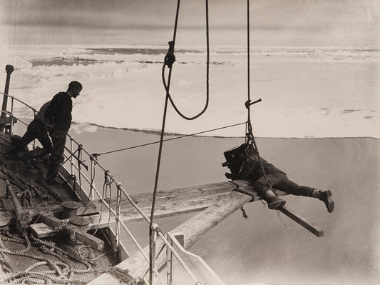 Classic photograph by Herbert Ponting from Captain Scott's expedition (1910-1913), showing Ponting filming the Terra Nova forcing the ice pack.
