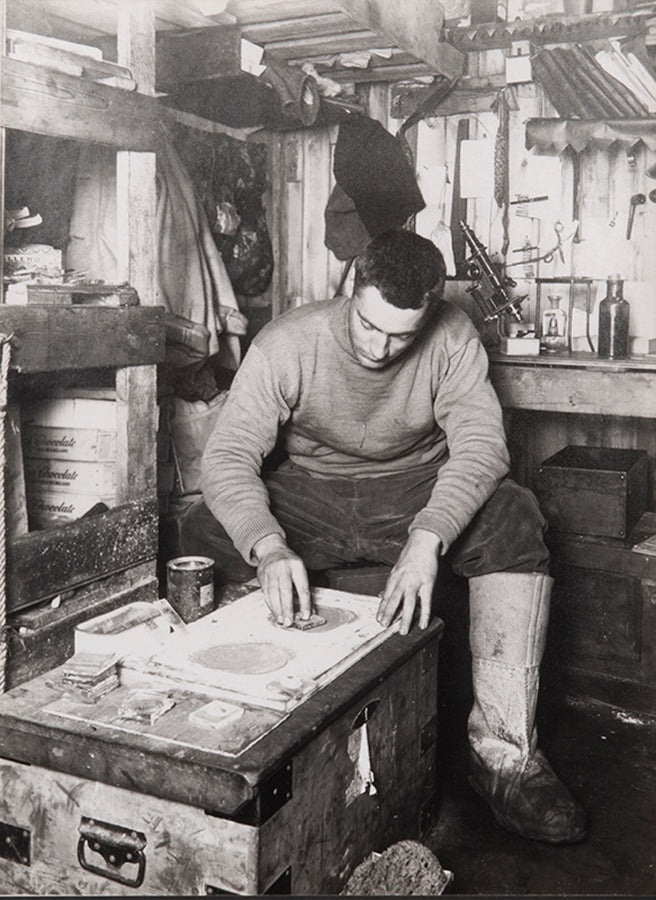 Classic Herbert Ponting photograph from Captain Scott's Terra Nova expedition (1910-1913), showing Frank Debenham grinding geological specimens.
