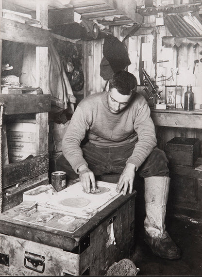 Classic Herbert Ponting photograph from Captain Scott's Terra Nova expedition (1910-1913), showing Frank Debenham grinding geological specimens.