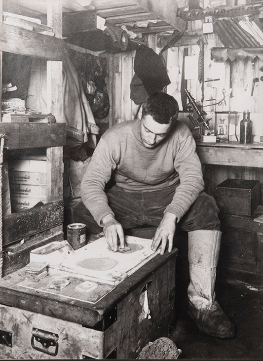 Classic Herbert Ponting photograph from Captain Scott's Terra Nova expedition (1910-1913), showing Frank Debenham grinding geological specimens.
