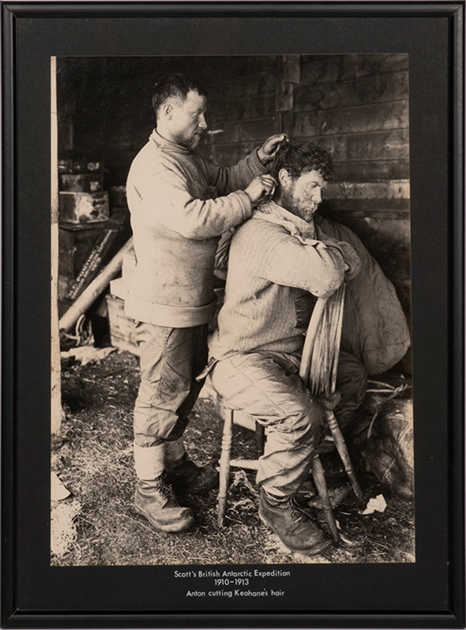 Classic photograph by Herbert Ponting from Captain Scott's Terra Nova expedition showing Anton cutting Keohane's hair.