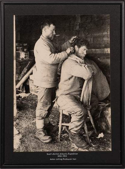 Classic photograph by Herbert Ponting from Captain Scott's Terra Nova expedition showing Anton cutting Keohane's hair.