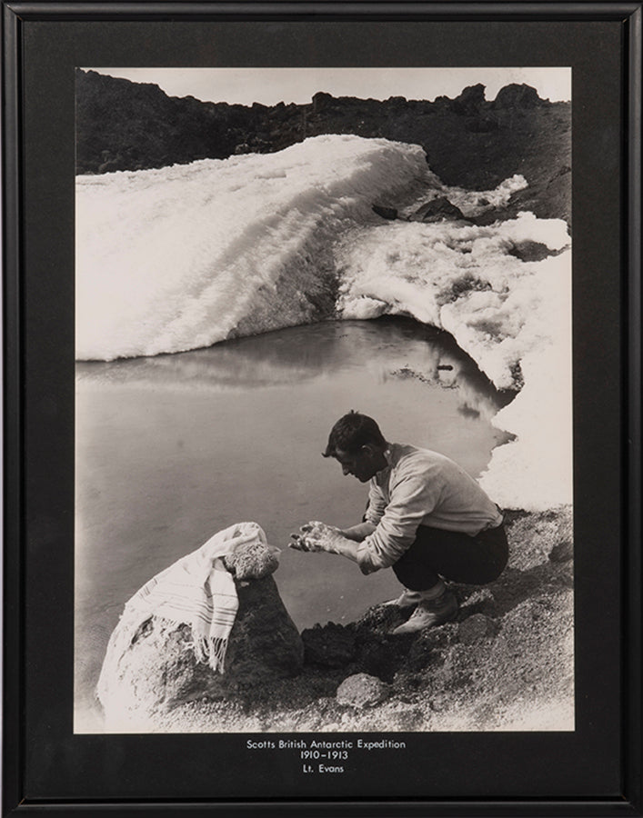 Classic Herbert Ponting photograph from Captain Scott's Terra Nova expedition (1910-1913), showing Lieut. Evans crouching down to wash his hands.