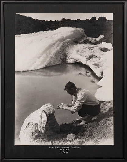 Classic Herbert Ponting photograph from Captain Scott's Terra Nova expedition (1910-1913), showing Lieut. Evans crouching down to wash his hands.