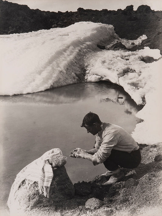 Classic Herbert Ponting photograph from Captain Scott's Terra Nova expedition (1910-1913), showing Lieut. Evans crouching down to wash his hands.