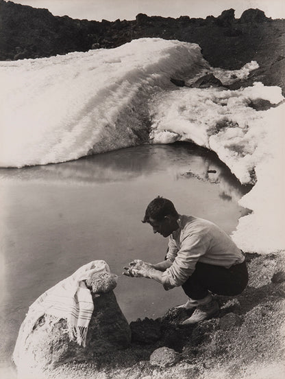 Classic Herbert Ponting photograph from Captain Scott's Terra Nova expedition (1910-1913), showing Lieut. Evans crouching down to wash his hands.
