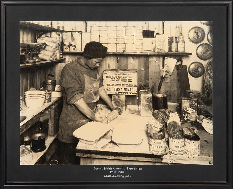 Classic Herbert Ponting photograph from Captain Scott's Terra Nova expedition (1910-1913), showing Thomas Clissold making rhubarb pies.