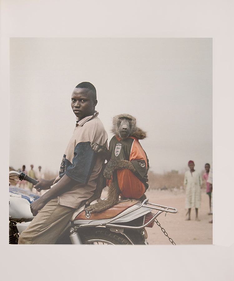 The men in Pieter Hugo's The Hyena and Other Men earn a living by performing before crowds in the peripheries of Nigerian cities, accompanied by hyenas, rock pythons and baboons, and selling traditional medicines.
