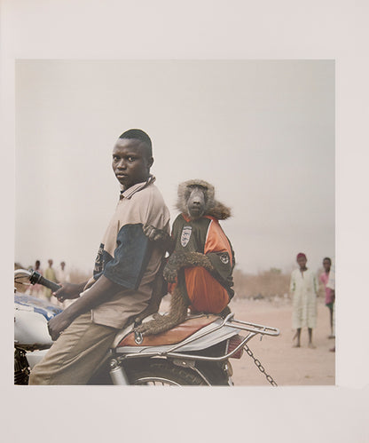 The men in Pieter Hugo's The Hyena and Other Men earn a living by performing before crowds in the peripheries of Nigerian cities, accompanied by hyenas, rock pythons and baboons, and selling traditional medicines.