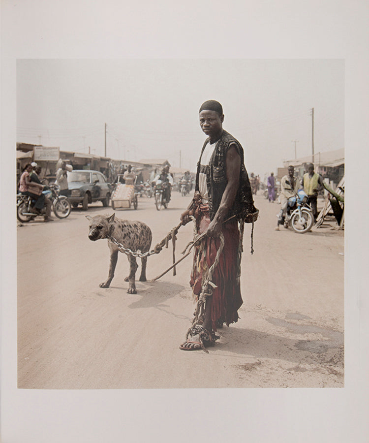 The men in Pieter Hugo's The Hyena and Other Men earn a living by performing before crowds in the peripheries of Nigerian cities, accompanied by hyenas, rock pythons and baboons, and selling traditional medicines.