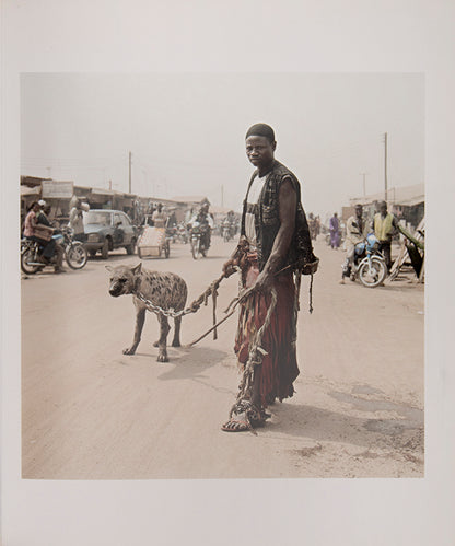 The men in Pieter Hugo's The Hyena and Other Men earn a living by performing before crowds in the peripheries of Nigerian cities, accompanied by hyenas, rock pythons and baboons, and selling traditional medicines.