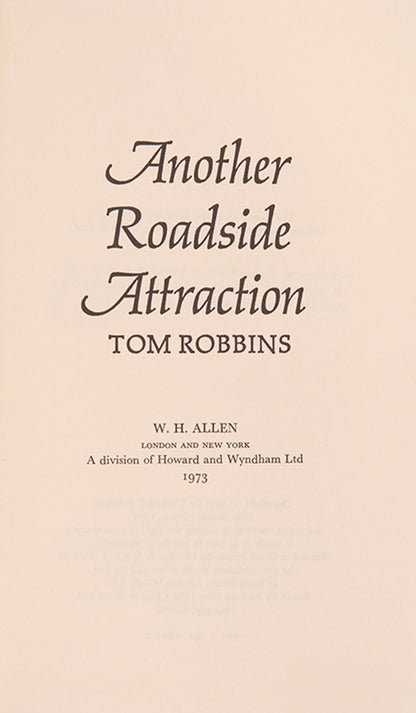 First UK edition of Another Roadside Attraction by Tom Robbins, with a signed photograph loosely inserted.