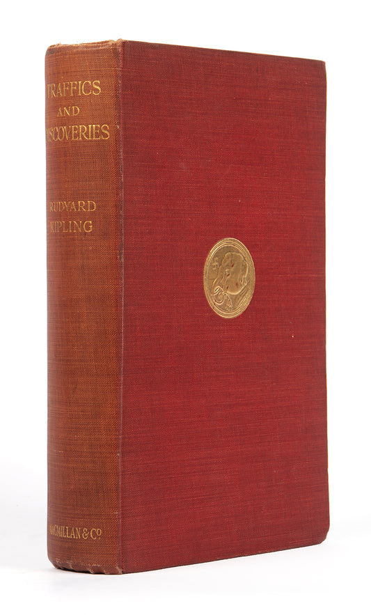First edition copy of Rudyard Kipling's Traffics and Discoveries a collection of short stories in the publisher's original red cloth with a gilt-blocked medallion to upper panel