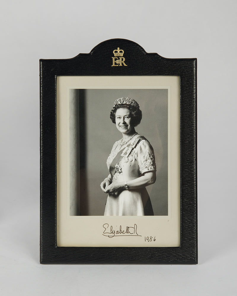 Two signed three-quater length photographic portraits by John Lawrence of HM Queen Elizabeth II and Prince Philip, dated 1986 in original frames by Longmire