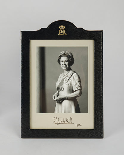 Two signed three-quater length photographic portraits by John Lawrence of HM Queen Elizabeth II and Prince Philip, dated 1986 in original frames by Longmire