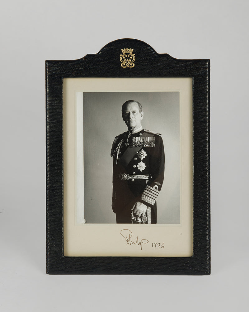 Two signed three-quater length photographic portraits by John Lawrence of HM Queen Elizabeth II and Prince Philip, dated 1986 in original frames by Longmire