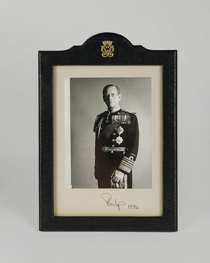 Two signed three-quater length photographic portraits by John Lawrence of HM Queen Elizabeth II and Prince Philip, dated 1986 in original frames by Longmire