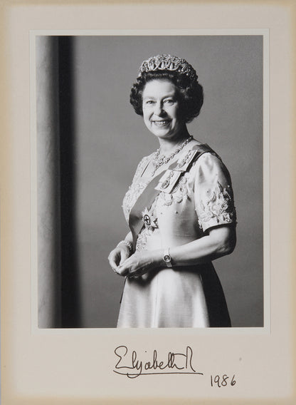 Two signed three-quater length photographic portraits by John Lawrence of HM Queen Elizabeth II and Prince Philip, dated 1986 in original frames by Longmire