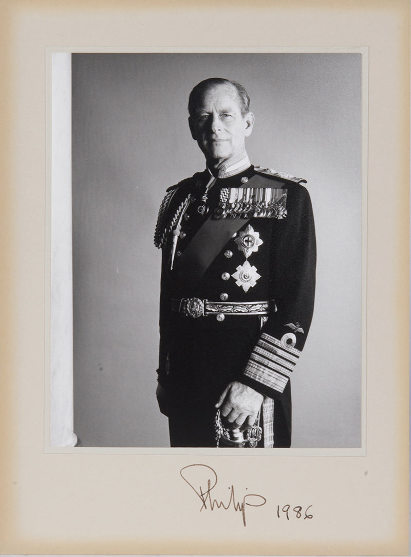 Two signed three-quater length photographic portraits by John Lawrence of HM Queen Elizabeth II and Prince Philip, dated 1986 in original frames by Longmire