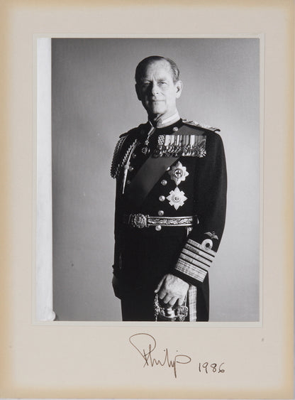 Two signed three-quater length photographic portraits by John Lawrence of HM Queen Elizabeth II and Prince Philip, dated 1986 in original frames by Longmire