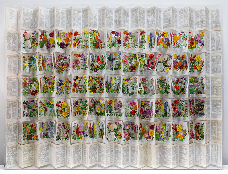 A cut book construction in an acrylic case by Jack Milroy, titled The Librarians Cottage Garden, 2026. 