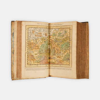 A remarkable copy of the second quarto edition of the Geneva Bible, complete with hand-coloured woodcut illustrations and 5 maps, and bound in seventeenth-century vellum gilt onlaid in red morocco