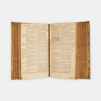A remarkable copy of the second quarto edition of the Geneva Bible, complete with hand-coloured woodcut illustrations and 5 maps, and bound in seventeenth-century vellum gilt onlaid in red morocco