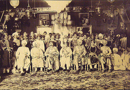 Two extraordinary group portraits of all the men from both families, one with piles of folded sari's in front of the seated men.