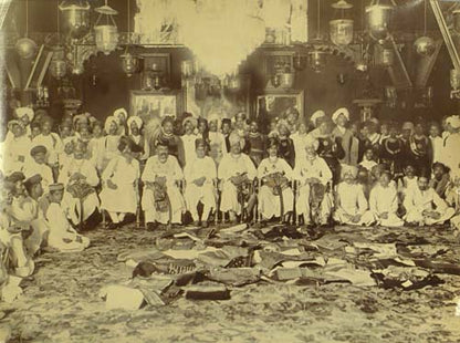 Two extraordinary group portraits of all the men from both families, one with piles of folded sari's in front of the seated men.