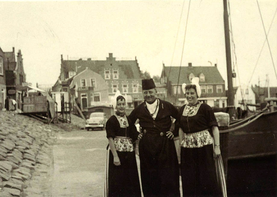 A trio wearing traditional regional costume at the Dutch fishing port of Volendam, Holland.