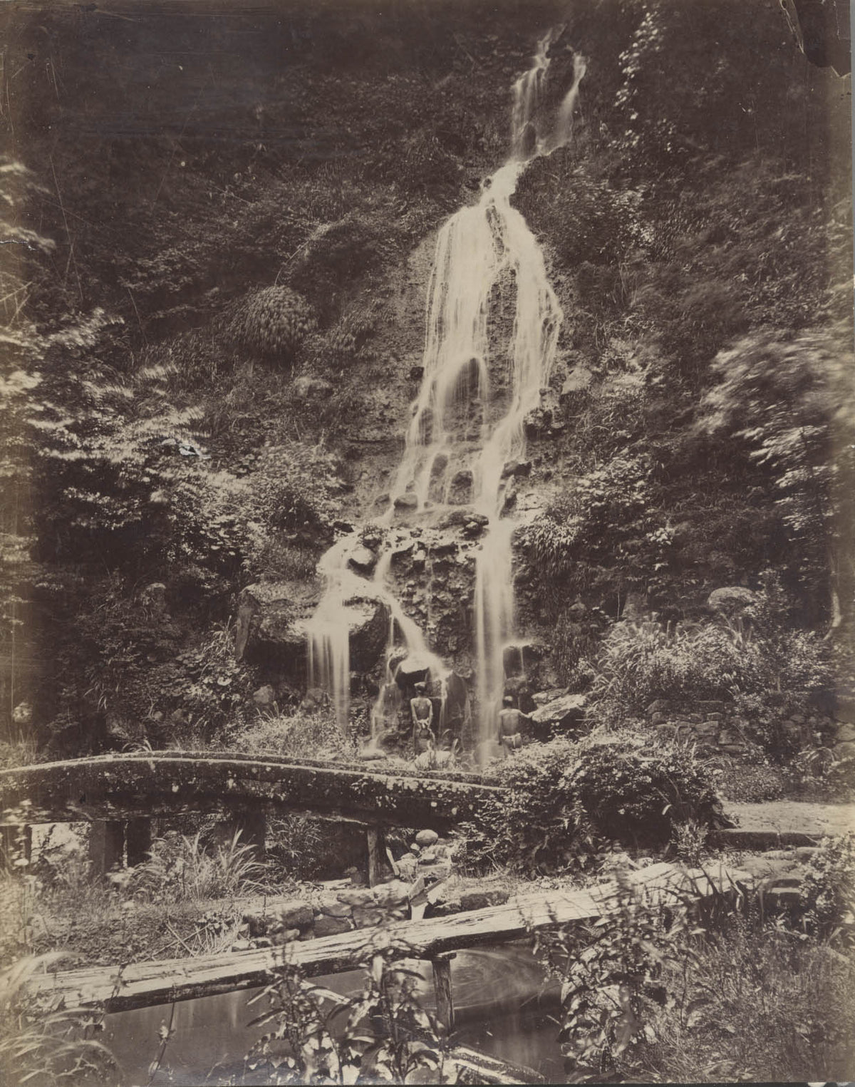 Man Standing Under Waterfall