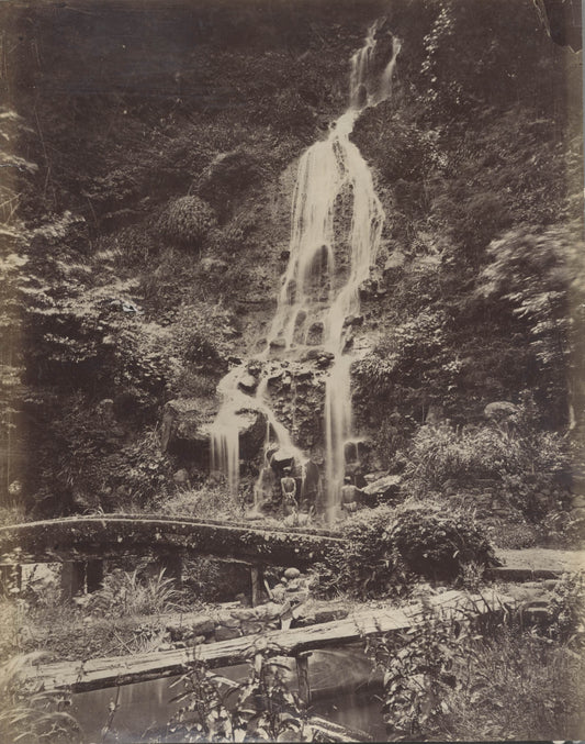 Man Standing Under Waterfall