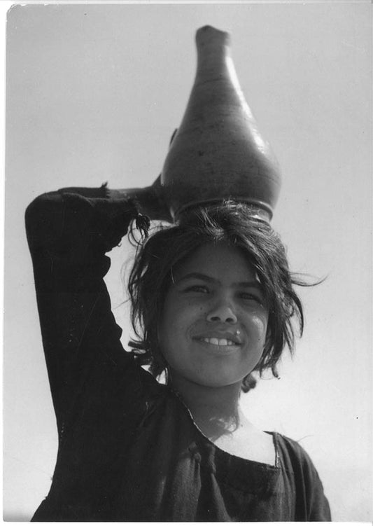 Girl carrying water jar near Luxor, Egypt.
